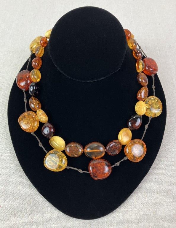 Two Amber-Toned Beaded Necklaces: Pair of necklaces composed of beautiful faux amber beads in warm, translucent tones. Necklace measures approx. 14" L. In good overall condition with minimal wear. 
