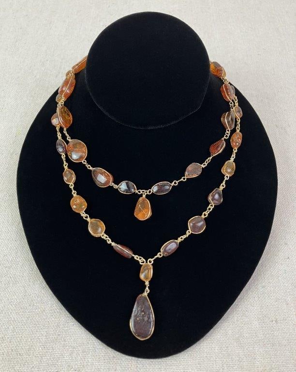 Amber-Toned and Goldtone Twisted Metal Necklace Pair: Pair of necklaces featuring artisan-style twisted metal designs accented with naturalistic faux amber elements set within wire mountings. One necklace measures approx. 16" L. In good condition with