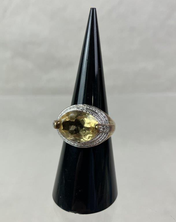 Sterling Silver and Citrine Cocktail Ring: Gold-plated sterling silver ring marked for silver content to interior, centering a bold oval-cut faceted citrine stone. Surrounding textural silverwork emulates the appearance of additional stones,