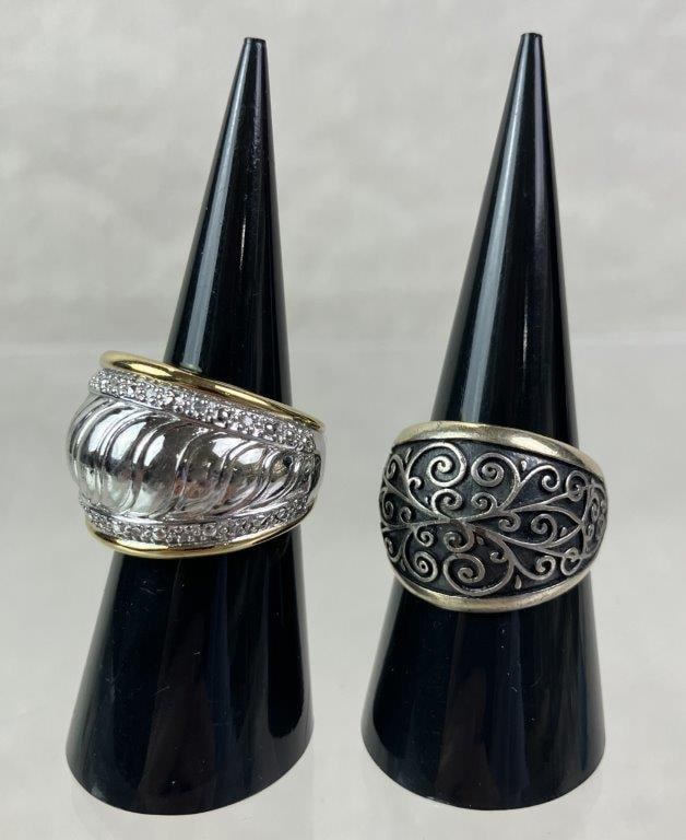 Two Statement Rings Including Sterling Example: Pair of robust statement rings featuring embossed textural scrollwork decoration. One ring marked for sterling content and is size 6; the other unmarked with elements of goldtone and silvertones and