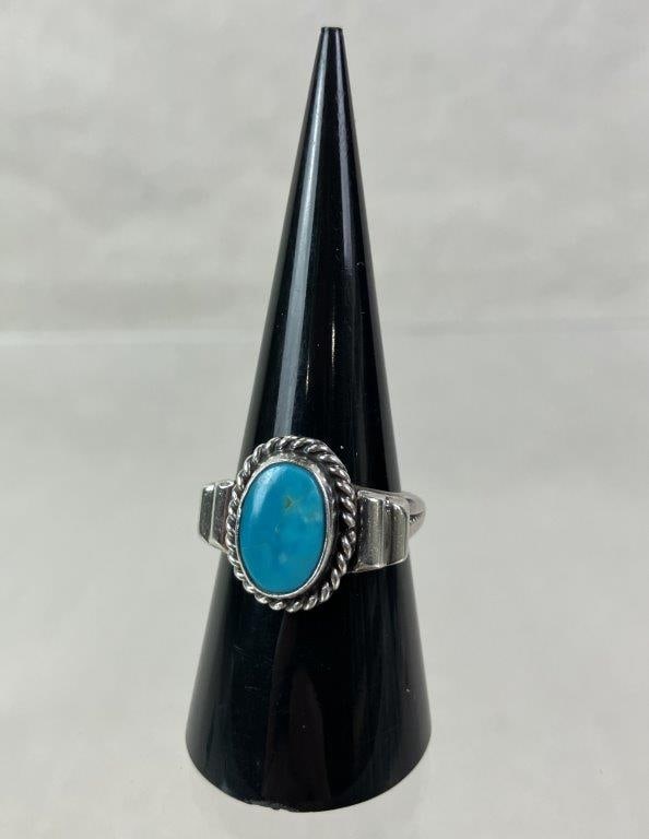 Native American Sterling Silver and Turquoise Ring: Native American sterling silver ring featuring a central oval turquoise cabochon framed by a rope border and mounted to a band accented with geometric elements. Ring size approx. 8. Unmarked but teste