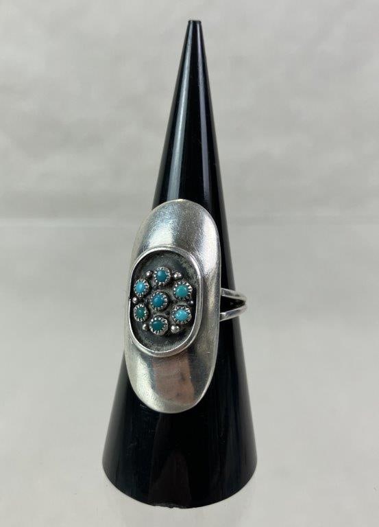 Native American Sterling Silver and Turquoise Petit Point Ring: Native American ring featuring a central petit point arrangement of small turquoise cabochons set within a robust oval sterling silver mount. Ring size approx. 7. Unmarked but tested for sterling cont