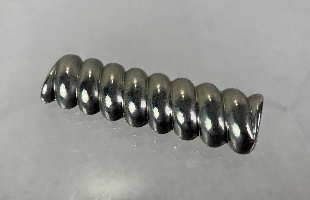Sterling Silver Modernist Spiral Brooch: Sterling silver brooch in an elegant modernist design, featuring a spiral or ribbed motif with clean, sculptural lines. Measures approx. 3/4" H x 2 5/8" W. Total weight approx. 9.61g. In good