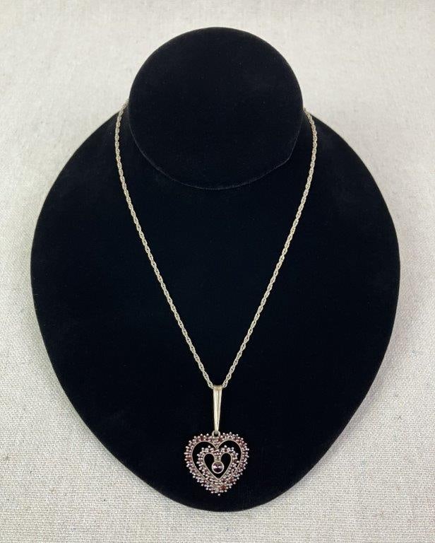 Platinum and Garnet Double Heart Necklace: Necklace featuring a double heart pendant set with a multitude of faceted garnet gemstones, enhanced by an elongated bail lending elegance to the design. Reverse of bail marked 900 denoting platinum