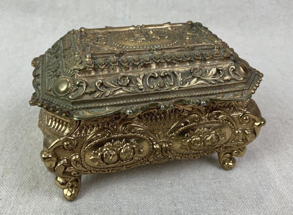 Vintage Himark Goldtone Trinket Box: Vintage Himark Japan trinket box executed in a late 19th century revival style, featuring ornate floral and rose detailing with scrolling decoration in a goldtone finish. Raised on feet and lined