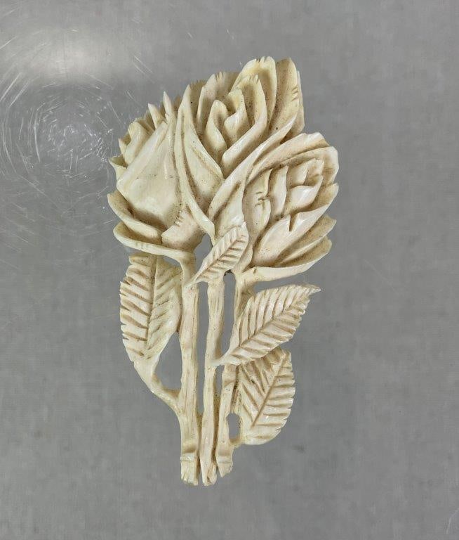 Carved Bone Three Roses Brooch: Elegant hand-carved bone brooch depicting three roses in relief with accompanying leaves and stems, showcasing refined craftsmanship and detailed artistry. Measures approx. 3" H x 1 7/8" W. In good
