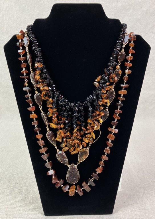 Three Amber-Toned Beaded Necklaces: Grouping of three necklaces composed of amber-style acrylic beads in warm, earthy tones. One necklace measures approx. 24" L. In good overall condition with some surface wear and minor abrasions consi