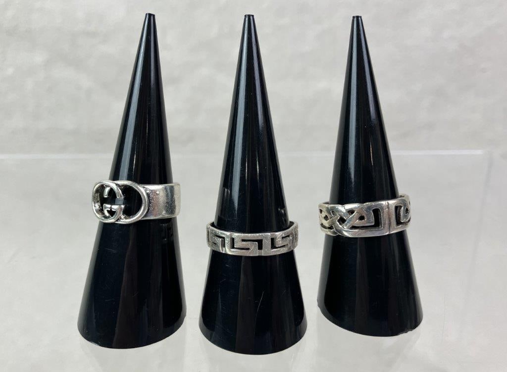 Three Sterling Silver Patterned Ring: Grouping of three sterling silver rings, each marked for silver content and featuring distinctive decorative motifs. Includes one interlocking motif ring (size approx. 6 1/2), one Greek key pattern ri