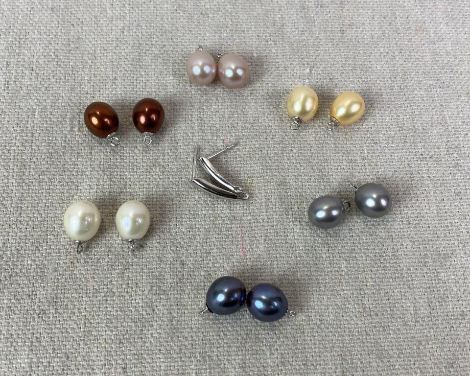 Assortment of Twelve Matched Pearls: Grouping of twelve pearls arranged in matched pairs, ideal for use in jewelry making. Includes chocolate, ivory, light gold, black, and additional complementary tones. One pearl measures approx. 1/4"