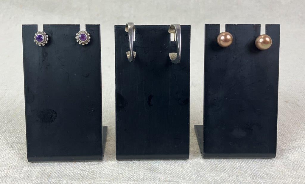 Three Pairs of Sterling Silver Earrings Including Chocolate Pearls: Grouping of three pairs of sterling silver earrings including one pair of chocolate pearl earrings, one pair of amethyst stud earrings set within rope-design sterling silver frames and posts, and one