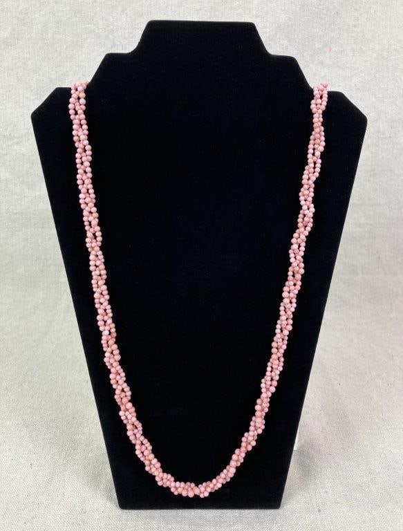 Pink Coral Bead Necklace: Pink coral bead necklace arranged in a woven torsade design, finished with gold-tone hardware. Measures approx. 15 3/4" L. In good condition with light wear consistent with use.