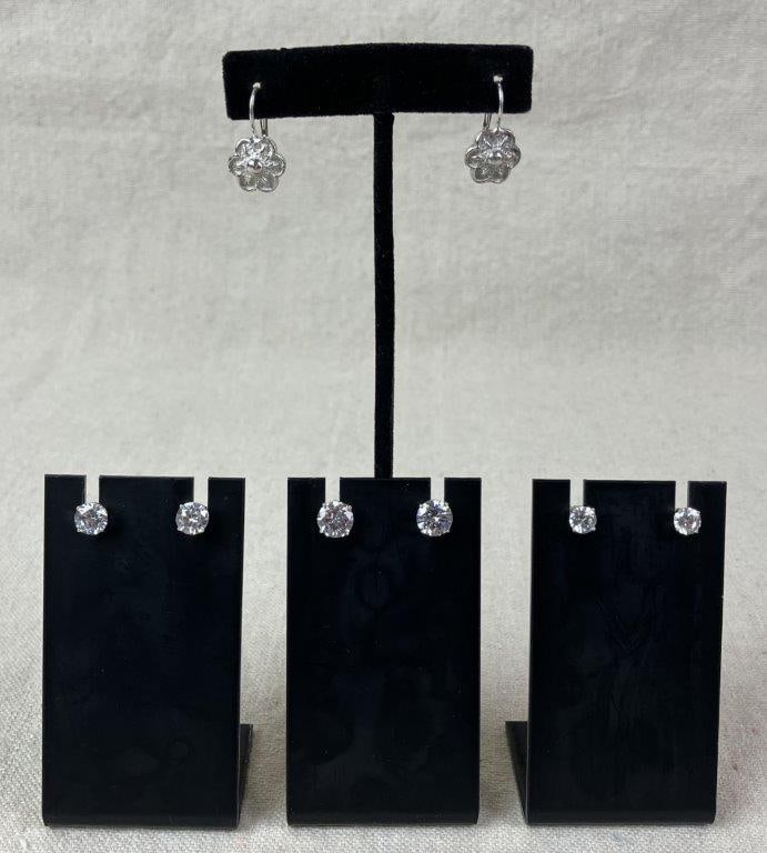 Sterling Silver Earring Grouping: Grouping of four pairs of sterling silver earrings including three pairs of stud earrings set with cubic zirconia stones and one additional pair designed in a floral motif. Floral earrings measure app