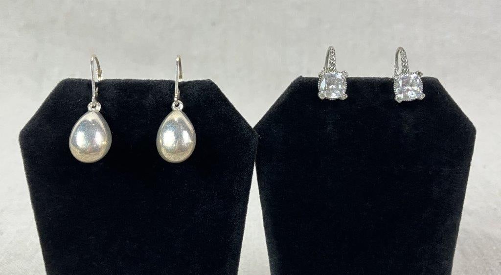 Two Pairs of Sterling Silver Earrings: Grouping of sterling silver earrings including one set in elegant teardrop forms and one set featuring square-cut cubic zirconia or clear faceted stones, framed by a raised latticework gallery. Total