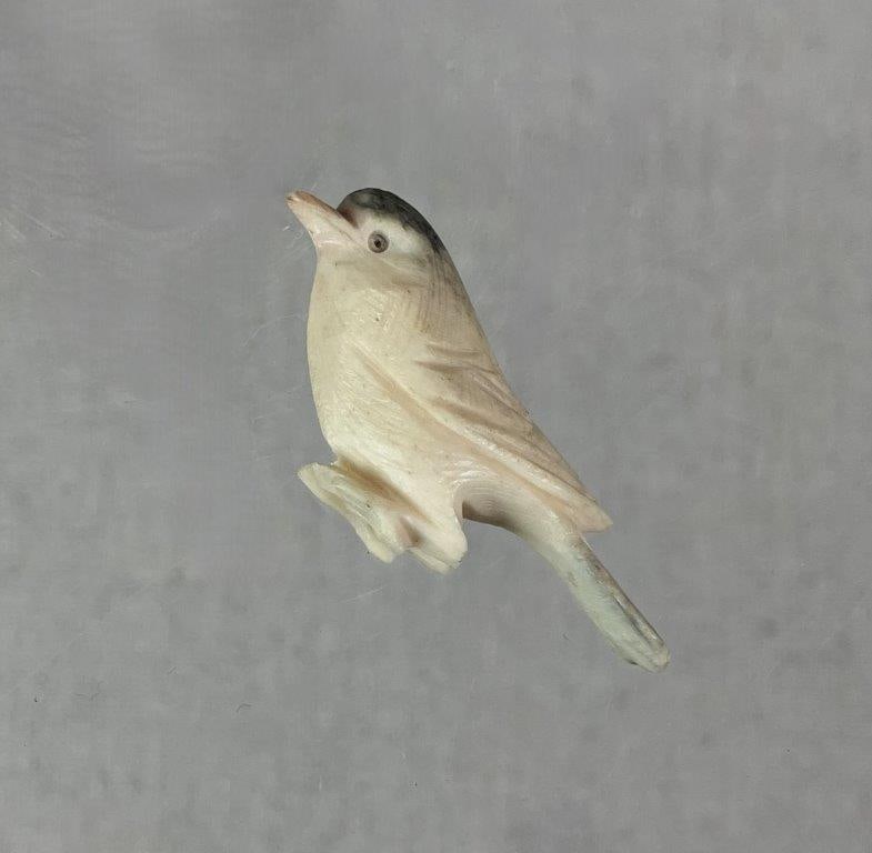 Carved Bone Bird Figure: Small bird figure hand-carved from bone, featuring incised detailing and hand-painted accents enhancing the form. Measures approx. 3/4" H x 1/2" W x 1 3/4" D. In good condition with light surface
