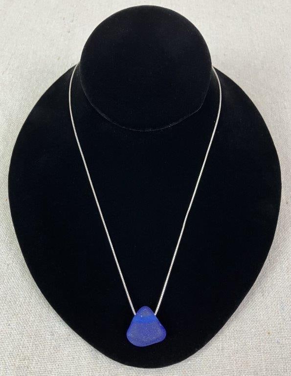 Sea Glass Pendant Necklace: Necklace featuring a deep royal blue sea glass pendant suspended from a delicate sterling silver chain. Pendant displays softly frosted surface typical of naturally tumbled sea glass. Chain measures