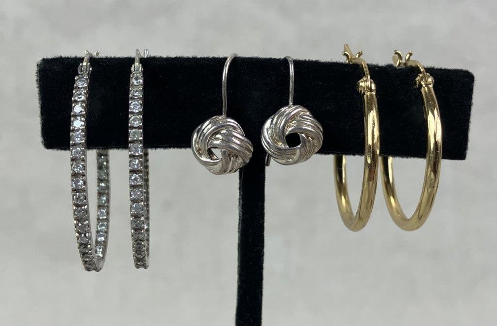 Three Pairs of Sterling Silver Earrings: Grouping of three pairs of sterling silver earrings including one pair of gold vermeil over sterling small classic hoops, one oblong pair accented with small faceted clear stones, and one pair of