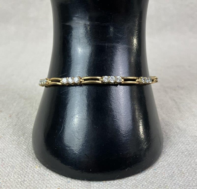 Vintage Roman Goldtone Tennis Bracelet: Vintage Roman brand tennis bracelet in gold tone finish, marked "Roman" near clasp. Designed with clear faceted stones arranged in three articulated sections and interspersed throughout the length of