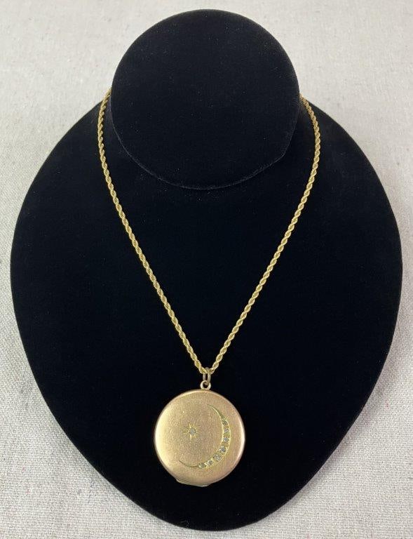 Late 19th Century Crescent Moon and Star Locket Necklace: Late 19th century goldtone locket decorated with recessed crescent moon and star motifs accented by cut faceted stones, retaining an antique photograph to the interior. Suspended from a simple