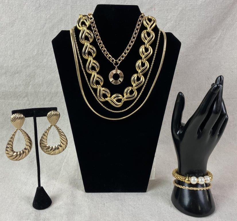 Goldtone Costume Jewelry Grouping: Assorted goldtone costume jewelry collection including vintage examples, comprised of three necklaces, two bracelets, one earring, and one fashionable belt. Belt features a bold lion head motif with