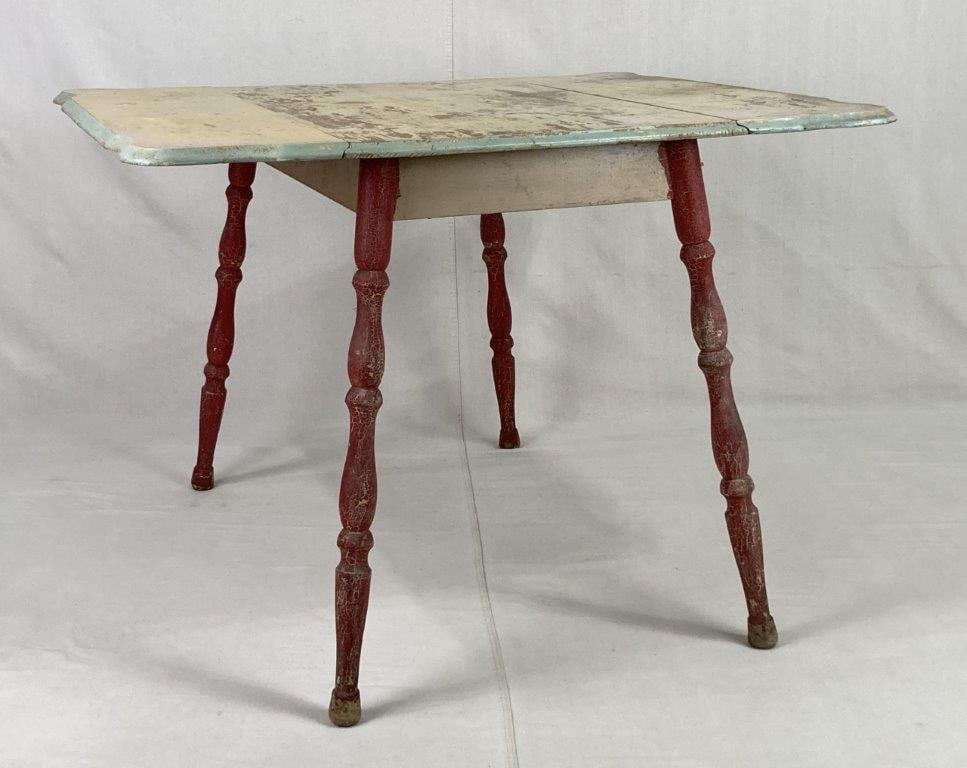 Country Painted Drop-Leaf Table: A rustic utilitarian piece featuring a traditional drop-leaf design and a distinctive two-tone finish. The table is supported by sturdy turned legs finished in a rich red paint, providing a vibrant