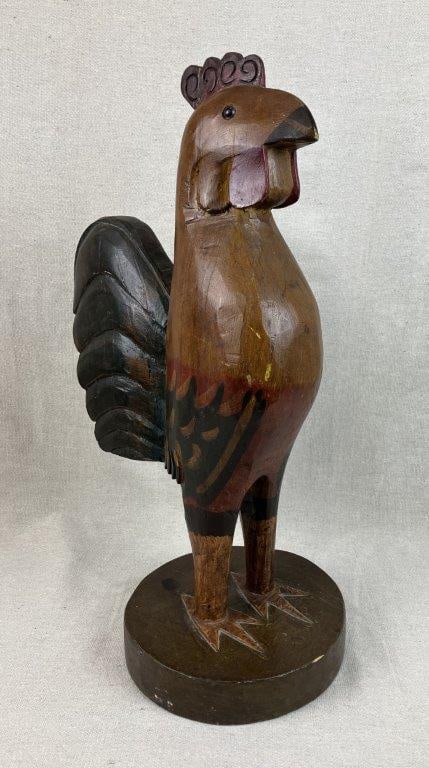 Folk Art Carved and Polychromed Rooster: A charming and statuesque hand-carved wooden figure featuring a whimsical avian form decorated with vibrant polychromed painted details. This folk art piece captures a quintessential rustic aesthetic