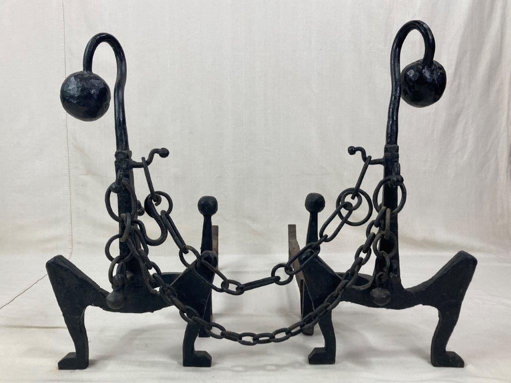 Arts and Crafts Ball and Chain Andirons: A pair of wrought iron andirons featuring novel, fluid forms characteristic of the Arts and Crafts movement. Each andiron is topped with a spherical finial and features sinuous, curving uprights