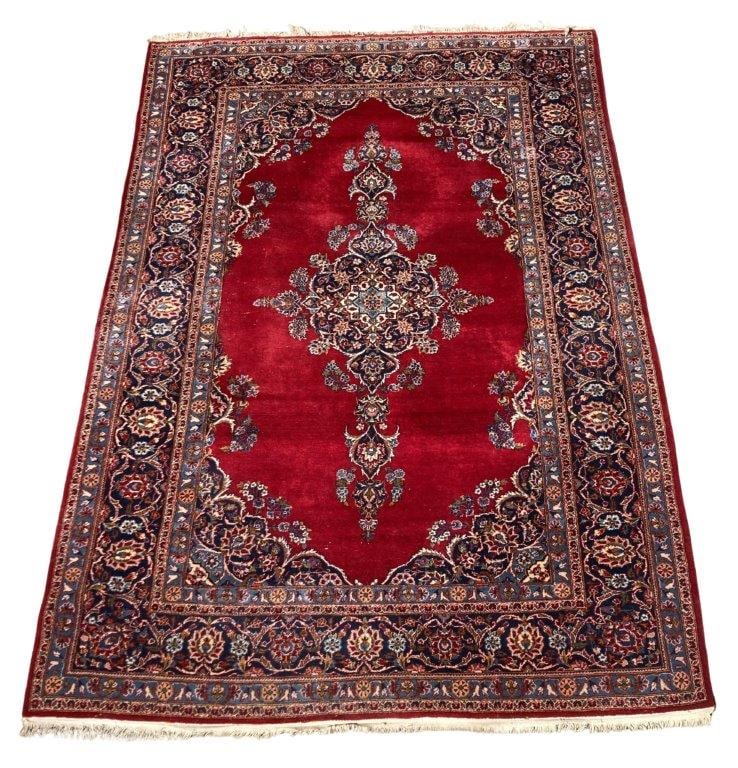 Persian Kashan Rug: A sophisticated and classic hand-knotted rug featuring a vibrant red field centered by an intricate floral medallion, all set within a traditional layout of scrolling palmettes and a multi-tiered