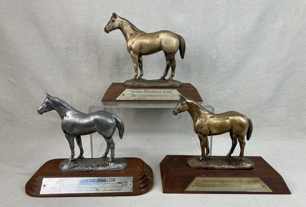 Three American Quarter Horse Association (AQHA) Trophies: 1977-1981, a distinguished set of equestrian awards featuring elegantly cast horse figurines finished with a metallic luster and securely mounted on polished wooden bases. This collection includes