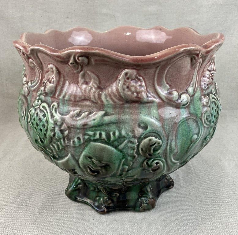 Majolica Jardiniere: An elegant and fluidly formed ceramic planter featuring a sophisticated blended glaze of pink, green, and earthy brown tones that accentuate its ornate relief decoration, which is adorned with
