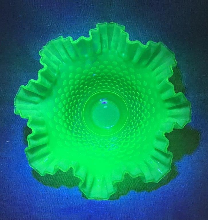 Fenton Emerald Green Hobnail Uranium Glass Bowl: A vibrant and tactile example of American art glass featuring the iconic raised hobnail pattern in a deep emerald green hue, expertly crafted with a characteristic crimped and ruffled edge that lends