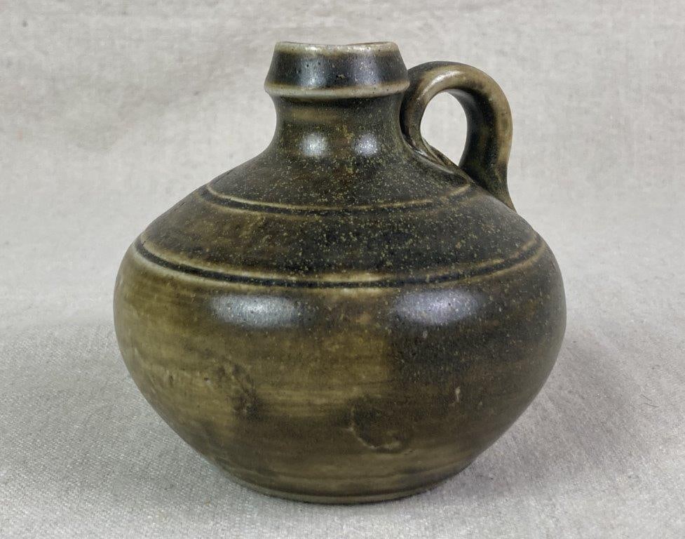 Ben Owen Pottery Jug: A hand-thrown pottery jug with a frog skin green glaze, featuring a rounded ovoid body and applied handle. Stamped “Master Potter Ben Owen” on the underside. Measures approximately 4'' H