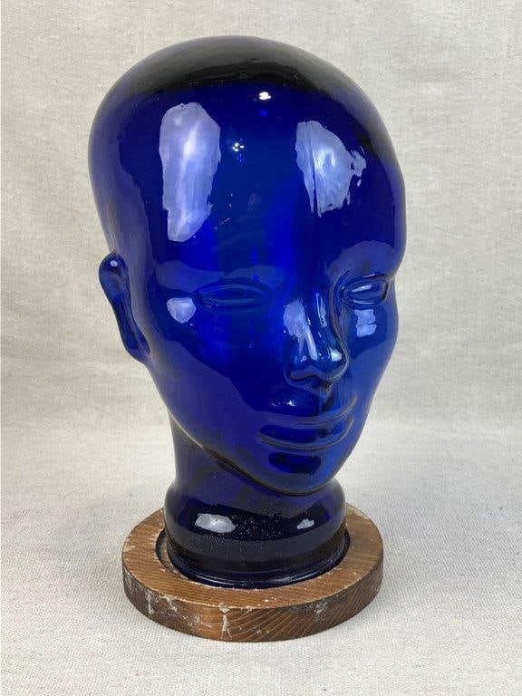 Cobalt Blue Glass Head: 20th Century, a striking decorative sculpture featuring a translucent pressed cobalt glass head modeled in a stylized, modernist form. The vibrant, deep-toned glass is designed to catch and refract