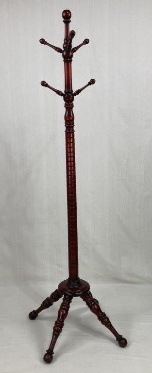 Victorian Turned Wood Coat Rack: A classic utilitarian piece featuring a stable tripod base and elegantly turned columns. Crafted from red cherry wood, this rack showcases the ornate woodworking and rich, warm tones characteristic