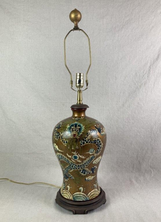 Mid-Century Modern Japonisme Table Lamp: Ceramic vase converted into a table lamp, featuring a gilt ground body encircled with dragon motifs in blue and white scales with green hair, depicted moving through stylized clouds. Features a gold