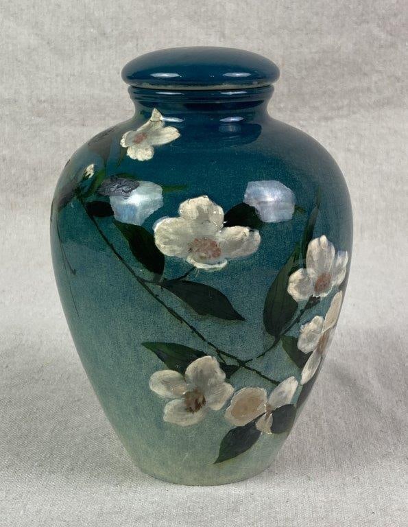 Avonware Pottery Jar: A pottery jar finished with a glossy glaze and decorated with delicate hand-painted floral motifs featuring white blossoms and green leaves. The glaze transitions from a rich teal tone to a lighter