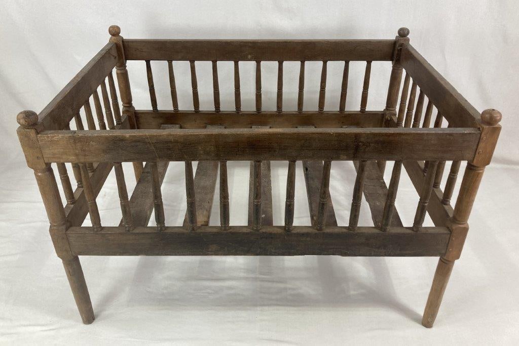 Southern Pine Crib: 19th Century, a substantial wooden crib of robust and sturdy construction characteristic of Southern furniture. The piece features turned spindles and four prominent corner posts topped with round