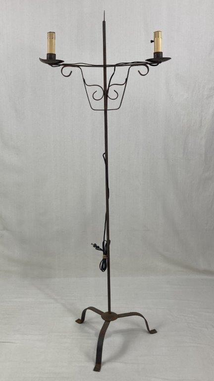 Wrought Iron Floor Lamp: A traditional lighting fixture featuring a sturdy footed base and elegant curving forms. The design is accented with decorative scrollwork at the crown and fixtures, lending a classic, artisanal