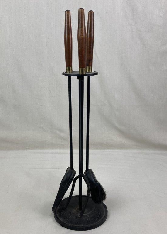 Mid Century Wrought Iron Fireplace Tool Set: Mid century fireplace tool set constructed in wrought iron with a black finish and fitted with walnut wood handles. The set includes a stand with coordinating tools designed in a clean functional