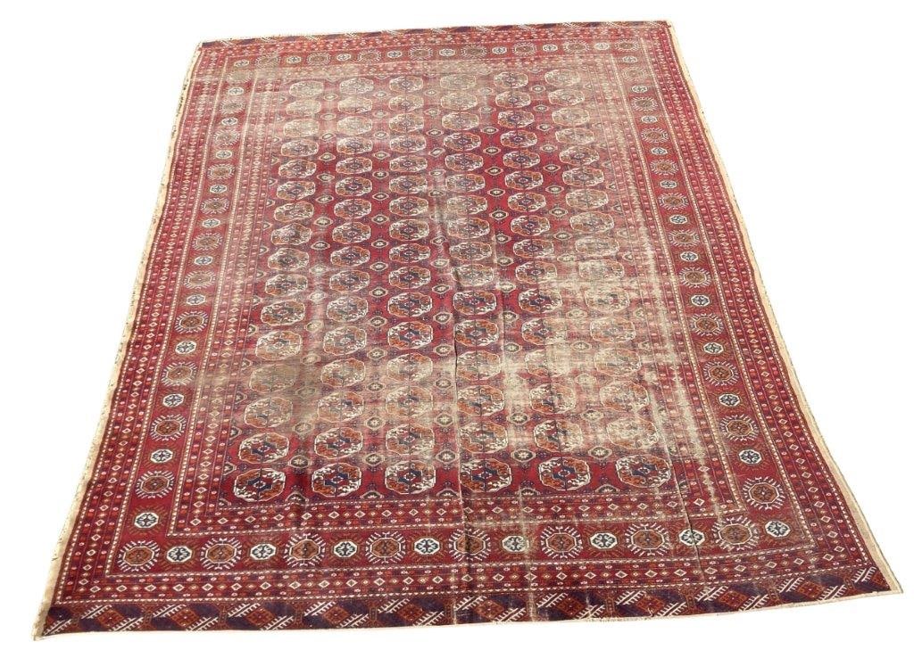 Large Bokhara-Style Hand-Knotted Wool Rug: Turkmen rug featuring a vibrant red field decorated with repeating rows of octagonal gul medallions. The design is framed by geometric guard borders containing stylized star motifs and intricate