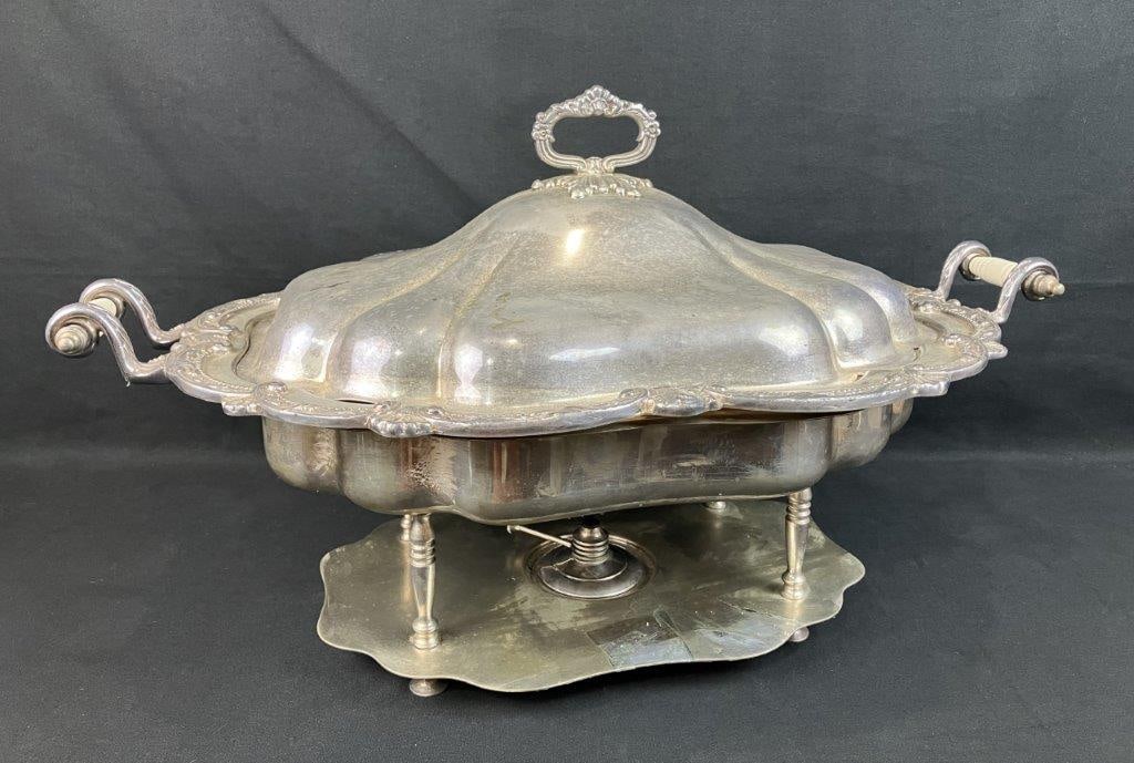 Silverplate Chafing Dish: Silverplate chafing dish featuring decorative elements with 19th century tableware appeal. The domed cover displays curving form with a scalloped edge accented by shell motifs and scrolling