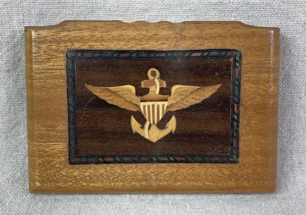EAWS Insignia Wood Cigarette Holder: A wood cigarette box featuring a central design with a mosaic-style border and inlaid wood depicting the Enlisted Aviation Warfare Specialist insignia. The side cover on the top reveals ten