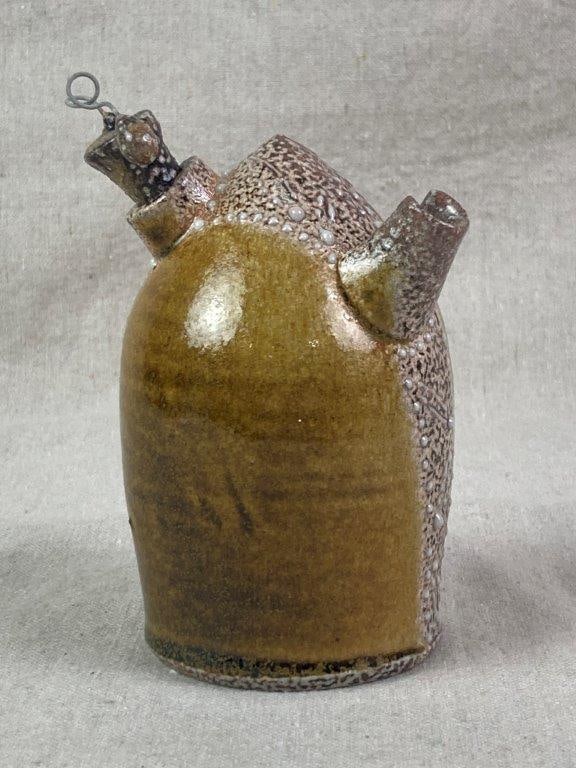 Small Studio Pottery Jug: A hand-formed pottery jug with a fitted stopper and wire accent, featuring an angled neck and spout applied to a cylindrical body. The surface is embellished with white slip-trailing applied as dots a