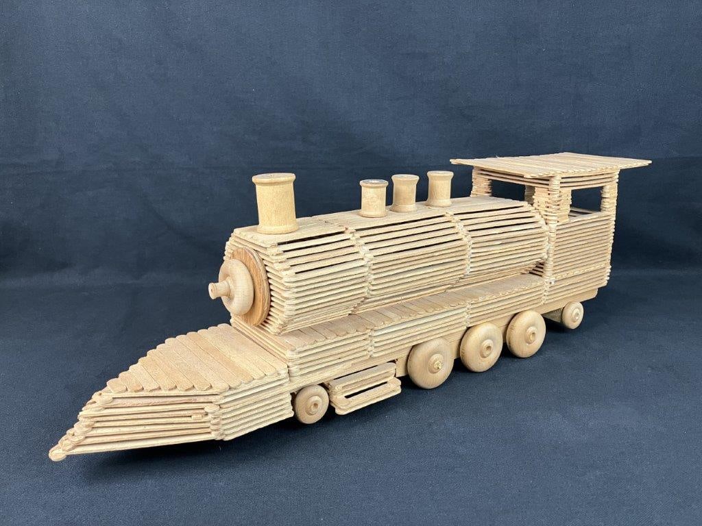 Folk Art Train Sculpture: Constructed from popsicle sticks and repurposed wood components including spools, displaying individual craftsmanship and folk art creativity. Measures approximately 7 1/2â€³ H x 23