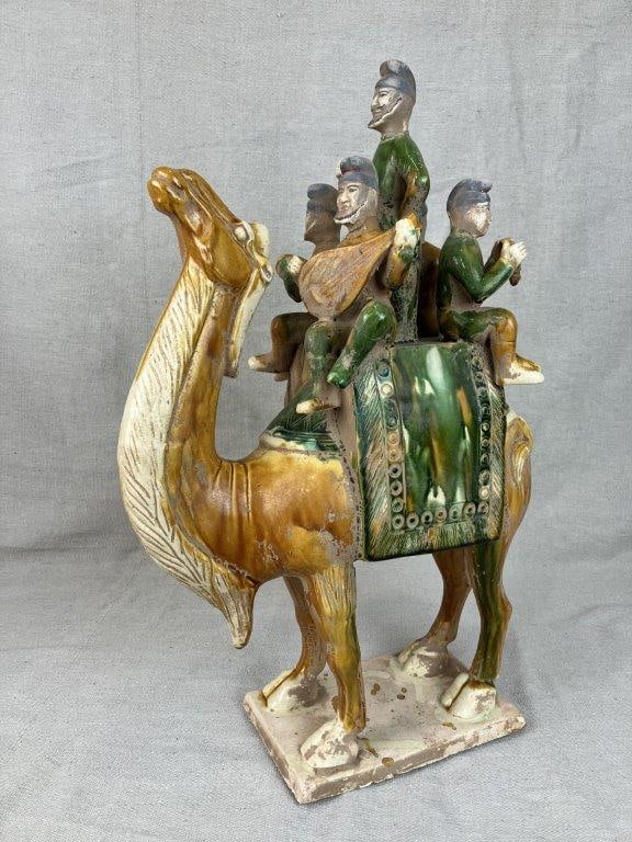 Chinese Tang Style Musicians on Camel Pottery: Glazed pottery sculpture in the traditional Tang dynasty style, depicting musicians seated atop a camel. Finished in the classic sancai three-color glaze technique with brown, green, and off-white