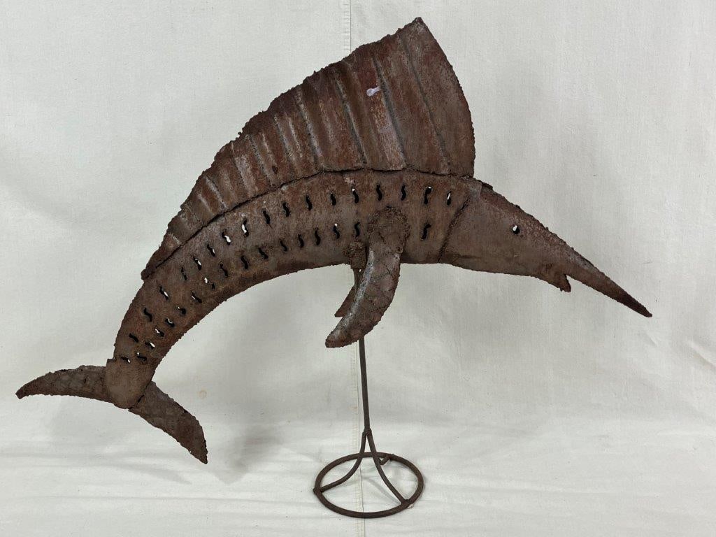 Jumping Sailfish Sculpture: Decorative sculpture depicting a leaping sailfish, mounted on a base with a rustic patina and warmly worn surface. Measures approximately 31 1/2â€³ H x 42â€³ W x