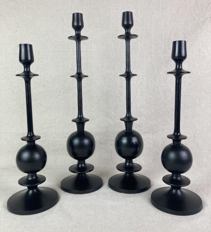 Four Madoc Candleholders: Group of four candleholders featuring sleek matte black aluminum construction with sculptural, tiered-stem silhouettes and round bases. Includes two small examples and two large examples. The largest