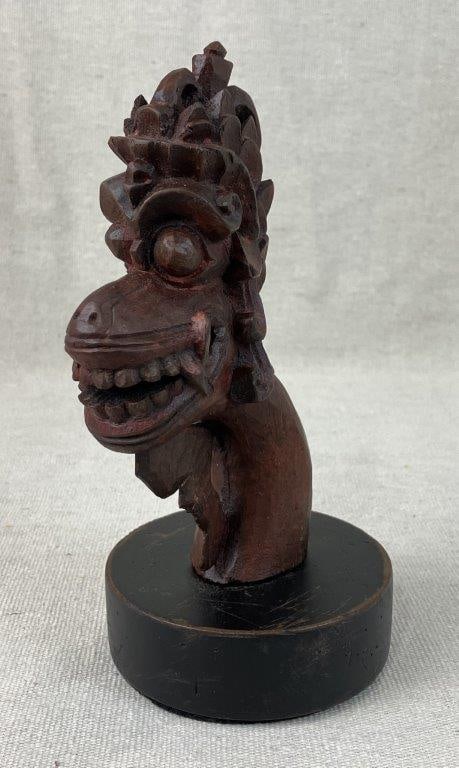 Hand Carved Indonesian Mythological Guardian Figure: Carved wood figure depicting a mythological guardian resembling a monkey form, finished with a deep patina and mounted on an added wood base. Measures approximately 8 1/2â€³ H x