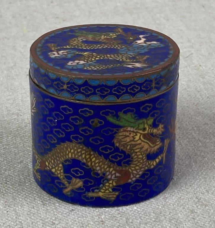 Chinese Dragon Cloisonne Trinket Box: Circular lidded vessel featuring a rich ultramarine blue enamel ground and intricate wirework. The decorative scheme showcases a traditional dragon, rendered in warm contrasting tones to define its