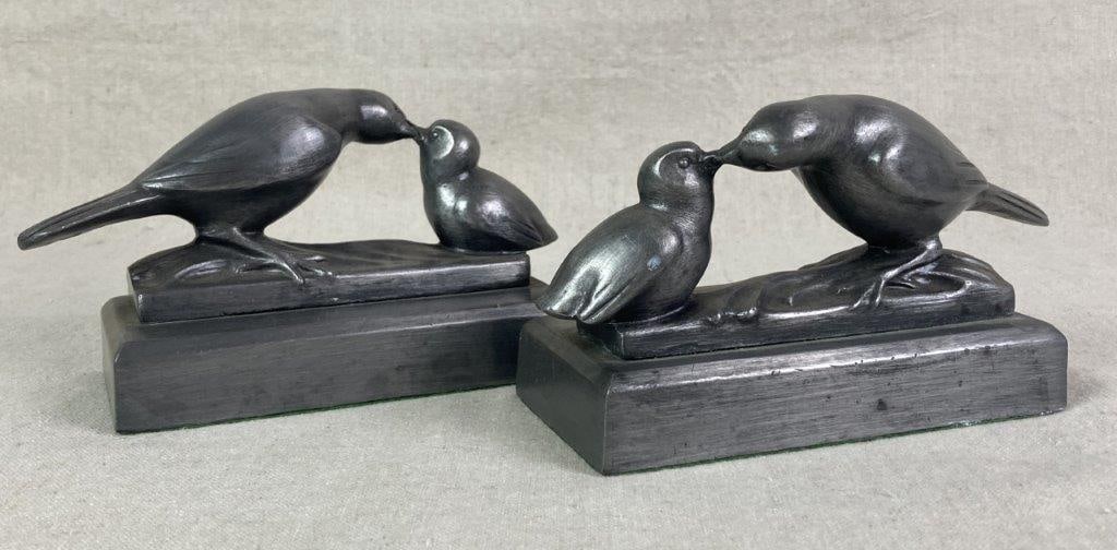 Cast Metal Feeding Bird Bookends: Pair of cast metal bookends with two birds, the larger bird is feeding the smaller bird, on a rectangle metal base, One measures approximately 3 7/8'' H x 3'' W x 6 1/2'' D, Good condition. 