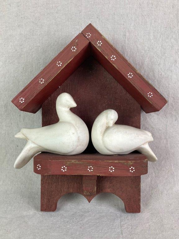 Folk Art Birdhouse Sculpture: Red painted wall-hanging birdhouse sculpture featuring two white ceramic doves nestled together, with a white dot pattern along the edges of the roof and platform and an aged patina. Measures